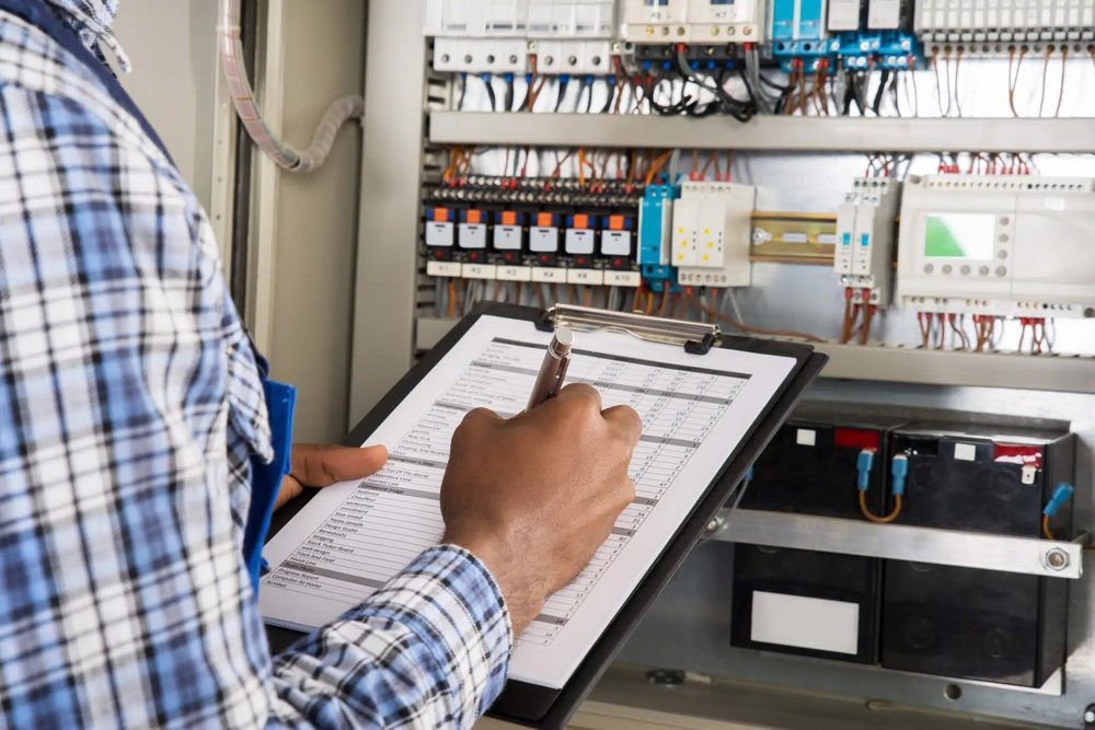 تصویر اجرای چک لیست تابلو برق صنعتی توسط تکنسین در محیط کارخانه